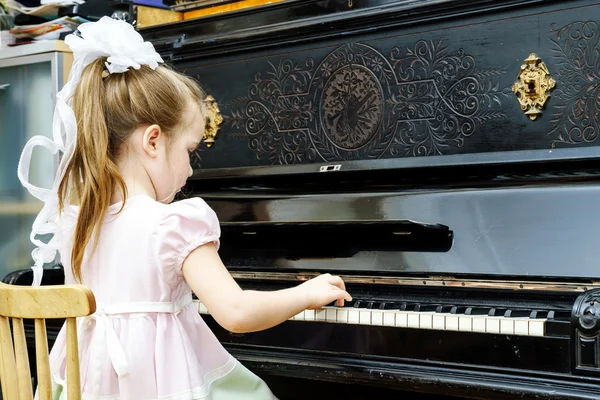 Menina bonito tocando piano velho — Fotografia de Stock