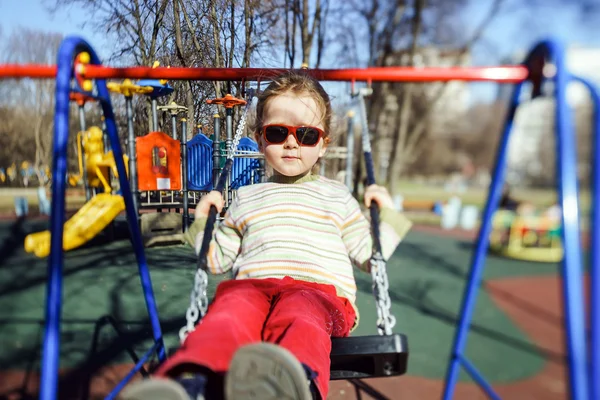 Bonito menina balançando seesaw no crianças playground — Fotografia de Stock