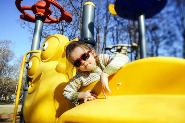 Söt liten flicka spelar på barn lekplats — Stockfoto