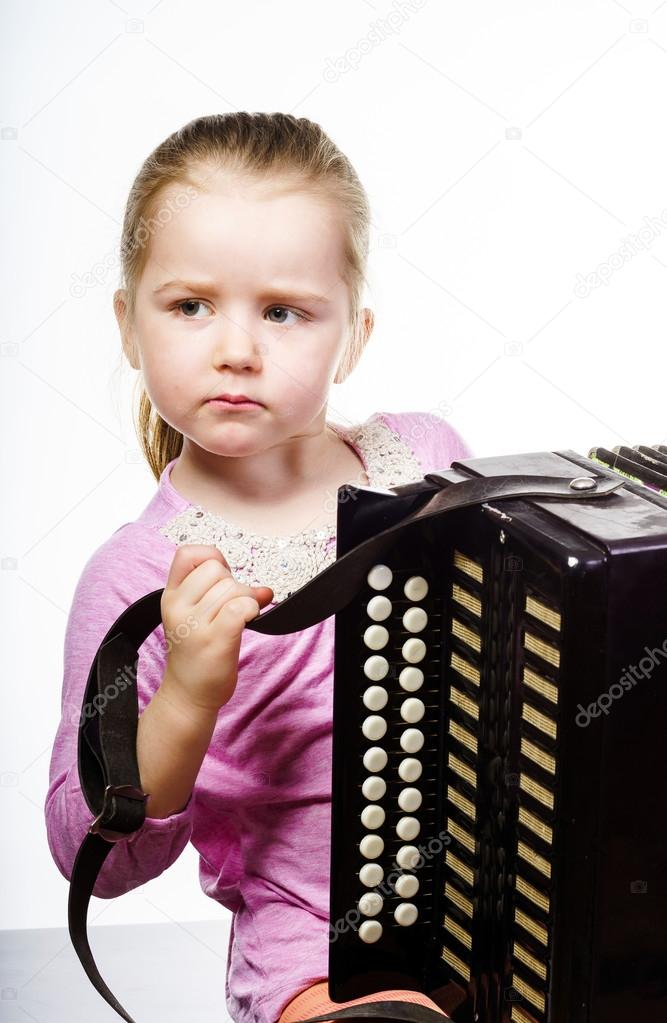Cute little girl playing harmonica, music education concept