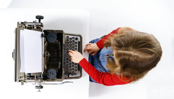 Vintage daktilo klavyede yazarak sevimli küçük kız — Stok fotoğraf