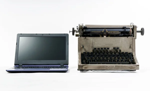 Новый ноутбук против старой винтажной пишущей машинки — стоковое фото