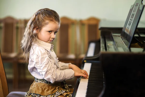 Schattig klein meisje spelen grand piano in muziekschool — Stockfoto