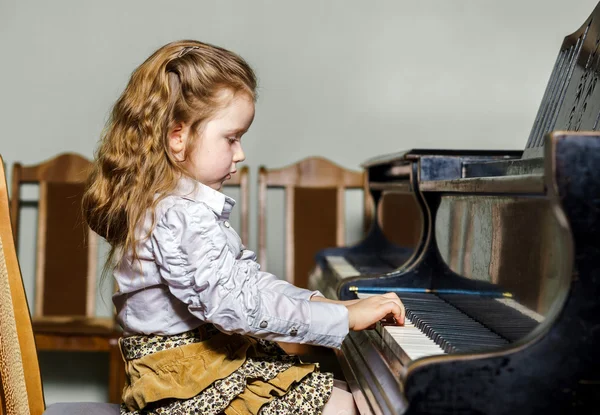 Linda niña tocando el piano de cola en la escuela de música — Foto de Stock