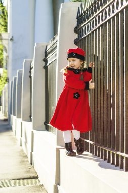 Sevimli küçük kız sokakta poz eski stil ceket giymiş