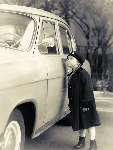 Sevimli küçük kız retro kat oldtimer arabanın yakınında poz giyinmiş — Stok fotoğraf