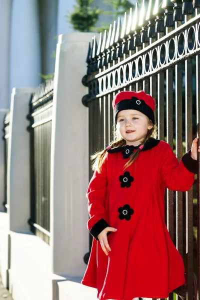 Cute little girl dressed in old-style coat posing on the street — Stock Photo, Image