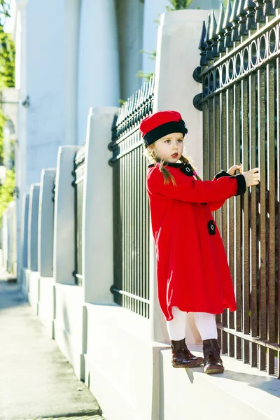 Petite fille mignonne vêtue d'un vieux manteau posant dans la rue — Photo