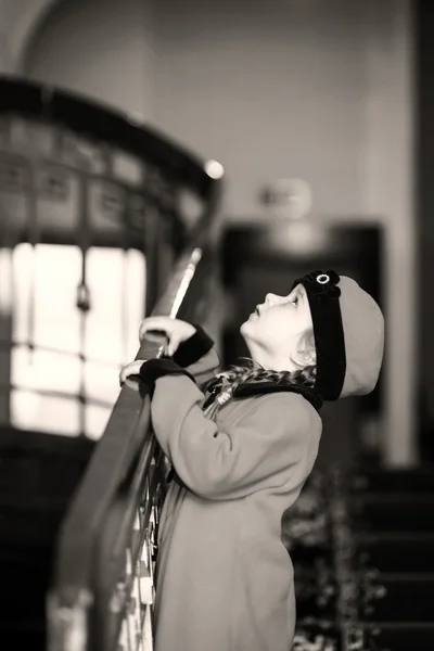 Petite fille mignonne vêtue d'un manteau de style rétro à l'intérieur de la vieille maison — Photo