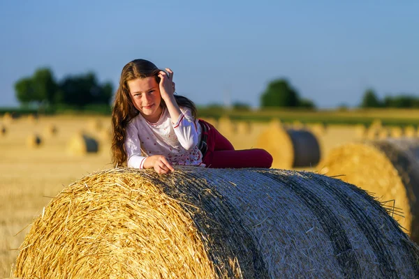 Dospívající dívka s dlouhými vlasy pózuje v létě pole, krajina — Stock fotografie