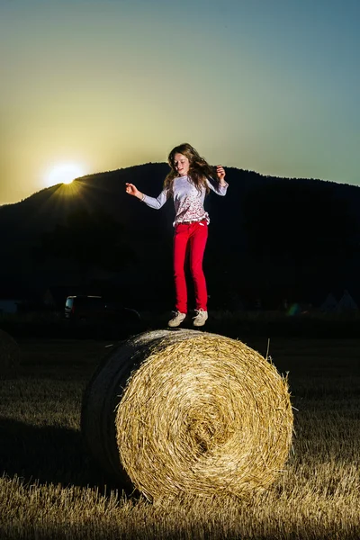 Teenage girl jumping from the haystack — Stock fotografie