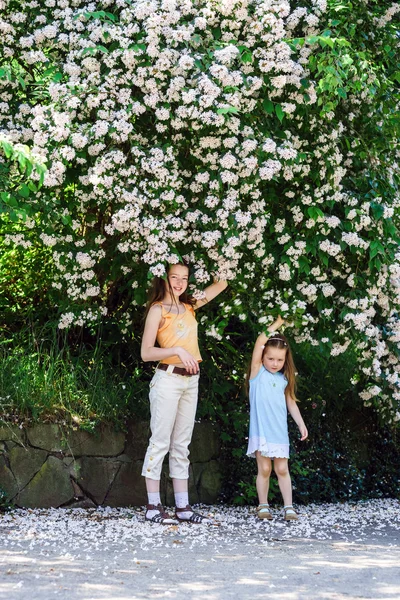 İki kız kardeş çiçeği ağaç ile oynamak