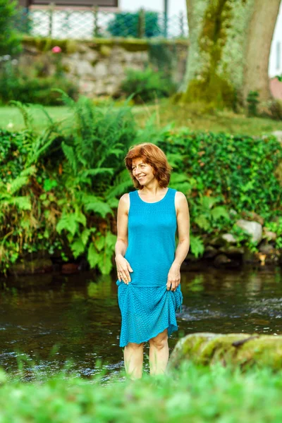 Giovane donna felice sul piccolo fiume in un villaggio — Foto Stock