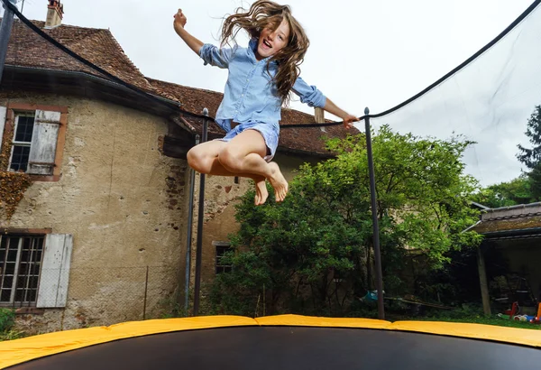 Cute teenage girl jumping on trampoline — Stock Photo, Image