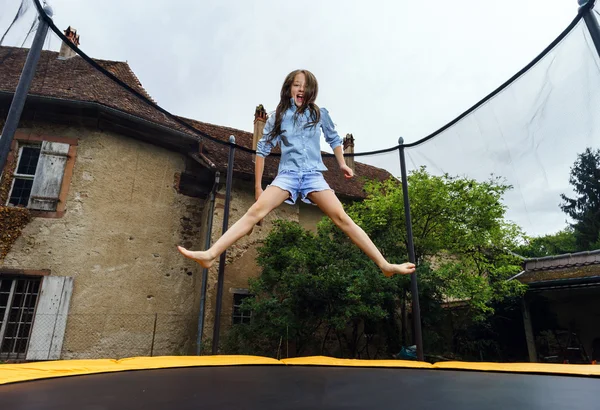 Cute teenage girl jumping on trampoline — Stock Photo, Image