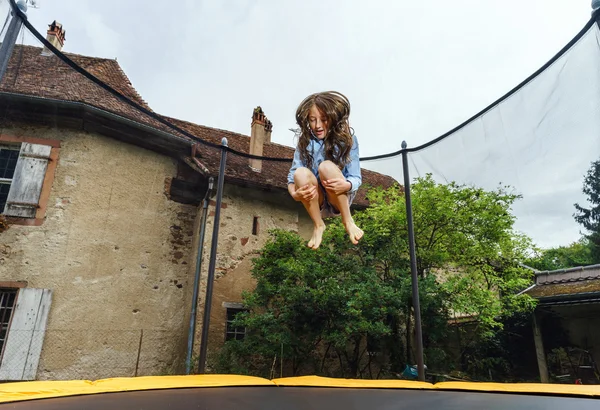 Aranyos tizenéves lány jumping a trambulin — Stock Fotó