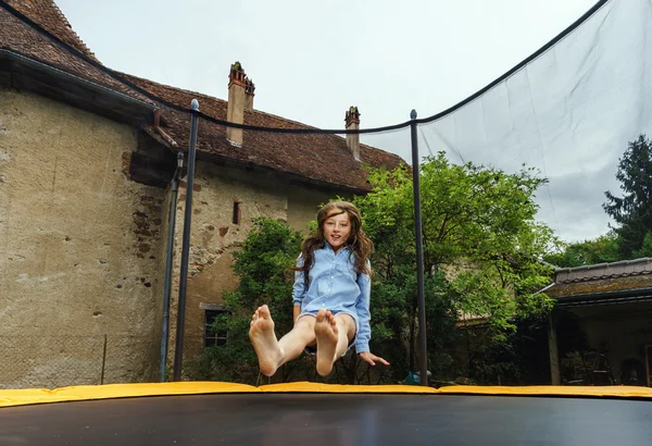 Cute teenage girl jumping on trampoline — Stock Photo, Image