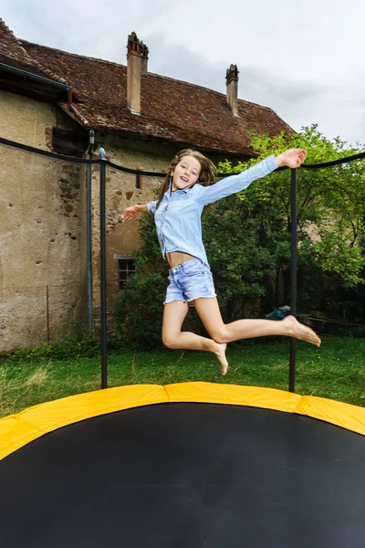 Gadis remaja yang lucu melompat di atas trampolin — Stok Foto