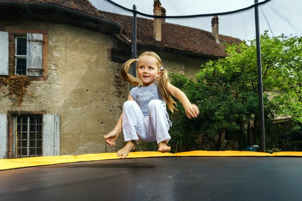 Gadis TK yang lucu melompat di atas trampolin — Stok Foto
