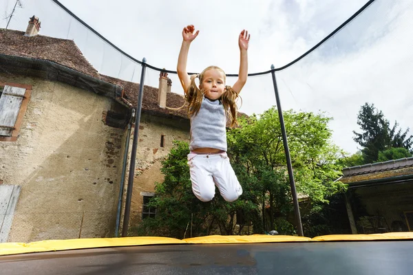 Aranyos óvodás lány jumping a trambulin — Stock Fotó