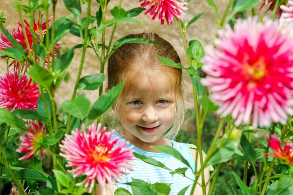 Schattig peuter meisje portret met natuurlijke bloemen — Stockfoto