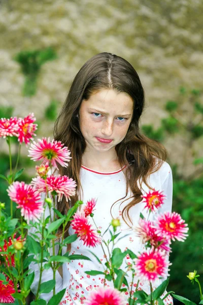 Teenage skolflicka stående med blommor — Stockfoto