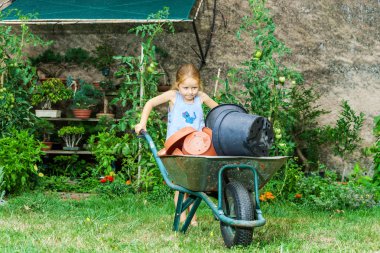 Sevimli küçük kız annesi bahçede yardım
