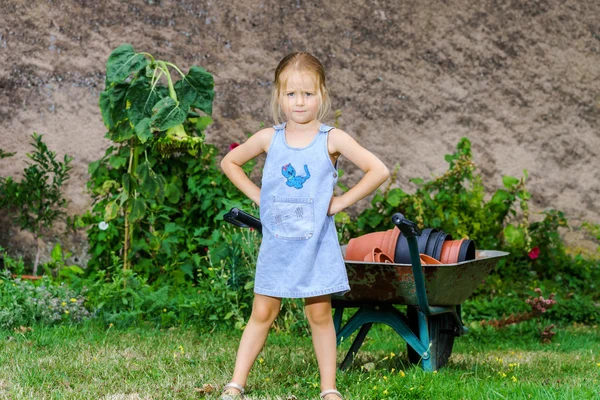 Милая маленькая девочка помогает своей матери на заднем дворе — стоковое фото