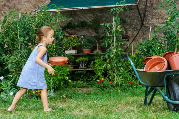 Carino bambina aiutando sua madre nel cortile — Foto Stock