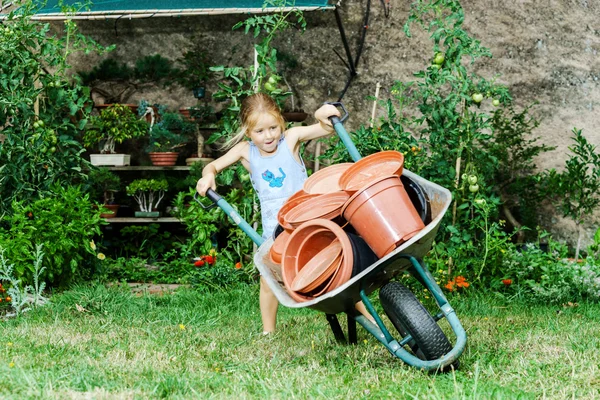 Petite fille mignonne aidant sa mère dans la cour arrière — Photo