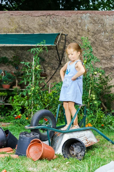 Мила дівчинка допомагає матері на задньому дворі — стокове фото
