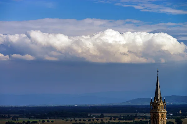Beautiful big cloud over the belltower of old church — Stock Photo, Image