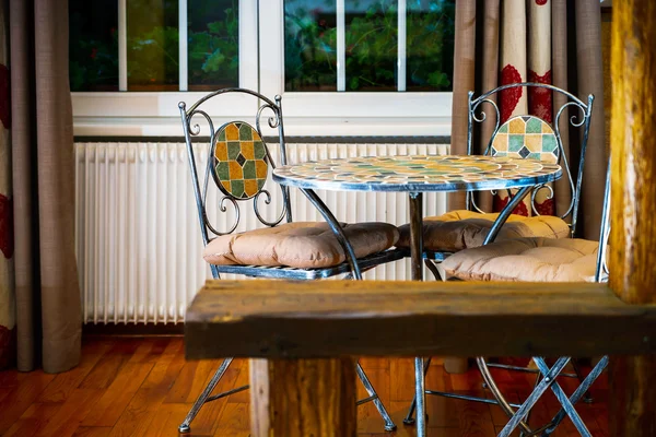 Drop-forged table with chairs in old-style room — Stock Photo, Image