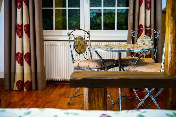 Mesa forjada a gota com cadeiras no quarto de estilo antigo — Fotografia de Stock