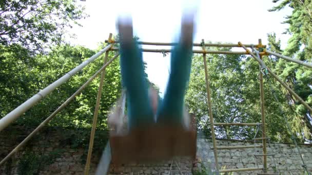 Linda niña balanceándose en el balancín en el patio trasero — Vídeo de stock