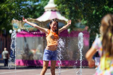 Çeşme sıçrama ile oynayan iki kız kardeş