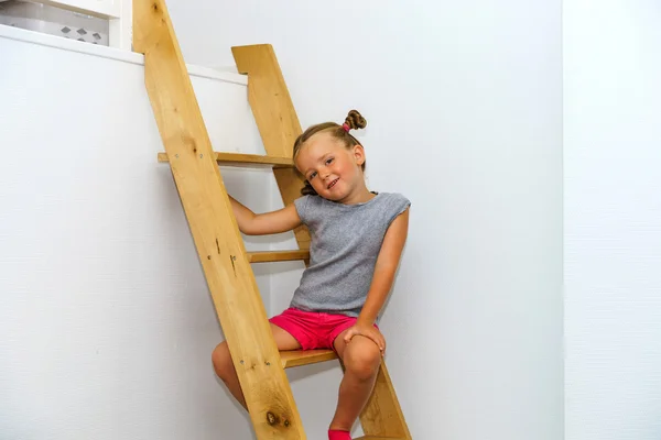 Cute little girl posing on staircase — Stock Photo, Image