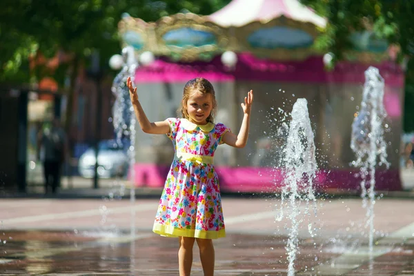 Linda niña jugando con salpicadura de fuente —  Fotos de Stock