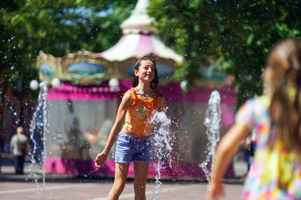 Dos hermanas jugando con salpicaduras de fuente — Foto de Stock