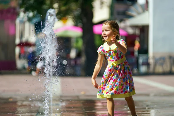Carino bambina che gioca con spruzzata fontana — Foto Stock