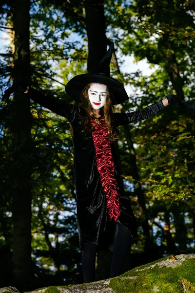 Mädchen im Wald im Halloween-Hexenkostüm — Stockfoto