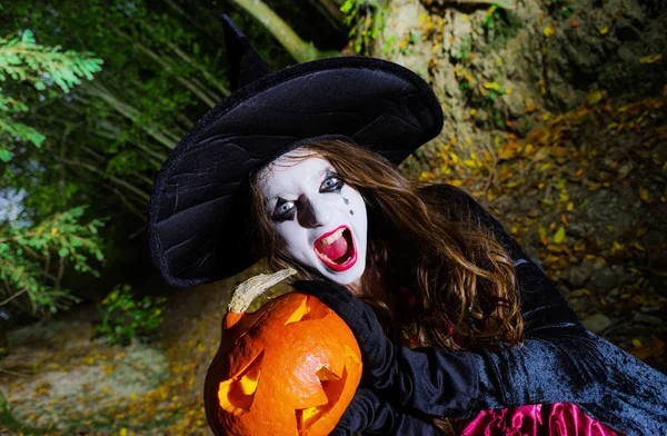 Teenager-Mädchen mit Kürbis im Halloween-Wald — Stockfoto