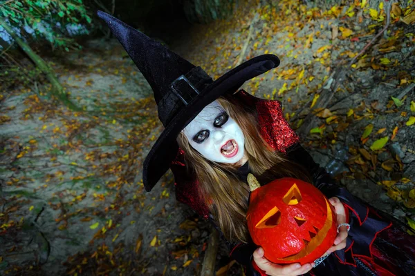 Kleines Mädchen im Hexenkostüm im Halloween-Wald — Stockfoto