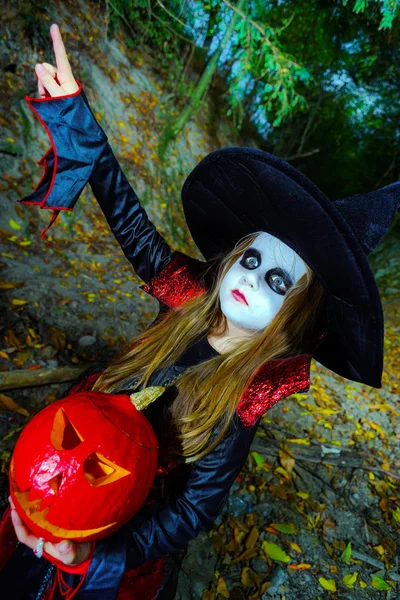 Menina vestida com traje de bruxa na floresta de Halloween — Fotografia de Stock