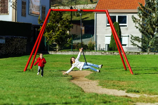 Dvě sestry, které se hraje na hřišti, slunečný den — Stock fotografie