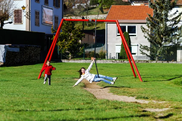 Dvě sestry, které se hraje na hřišti, slunečný den — Stock fotografie