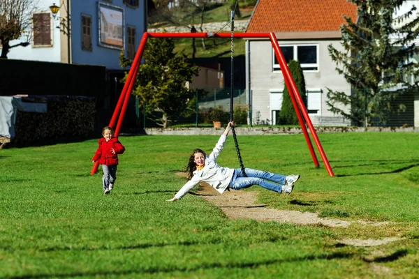 Dvě sestry, které se hraje na hřišti, slunečný den — Stock fotografie