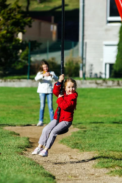 Două surori jucându-se pe terenul de joacă, zi însorită — Fotografie, imagine de stoc