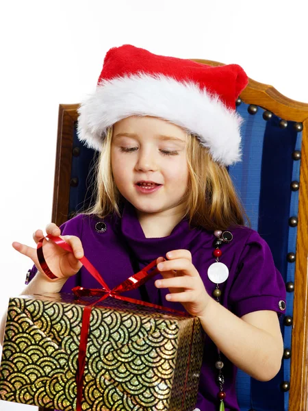 Cute little preschooler girl in red santa hat with gift box — Zdjęcie stockowe