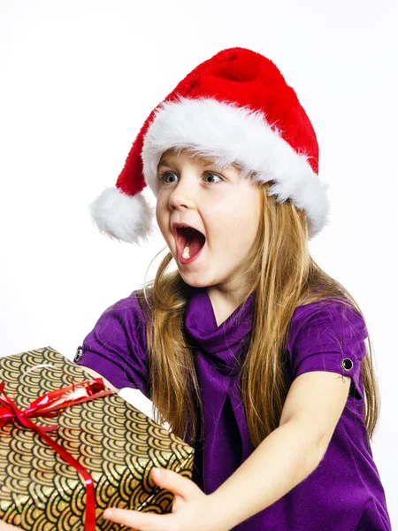 Cute little preschooler girl in red santa hat with gift box — Stock fotografie